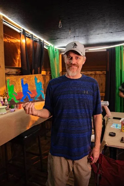 A guest with his completed colorful canvas