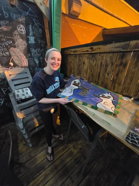 A guest painting a colorful doormat