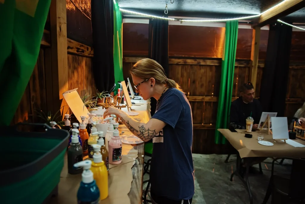 Participants paint together at the outdoor tables.