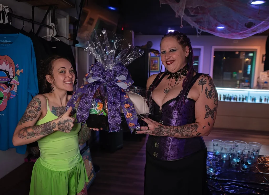 Two Halloween costume contest participants pose with a prize basket.