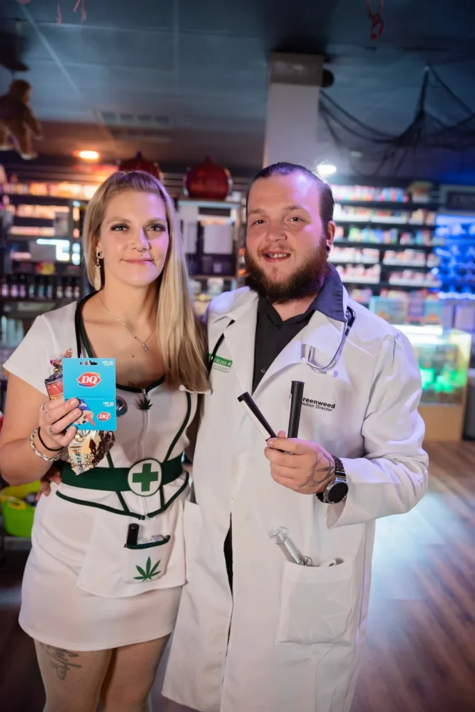 Two costumed guests pose together with the event backdrop.